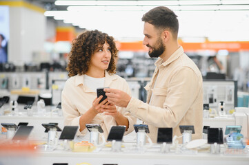 Couple choosing smartphone in electronics store