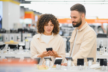Couple choosing new smartphone in electronics store