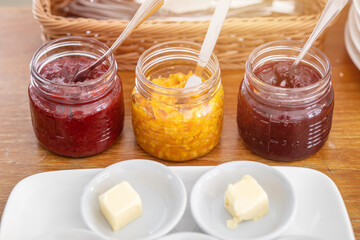 Multiple flavor of Jam and fresh butter for eat with bread morning meal preparing set on the table