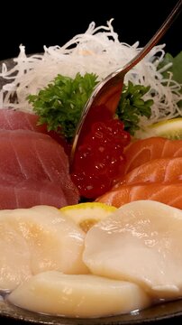 Spoon Adding Salmon Roe to Japanese Sashimi Sushi Set