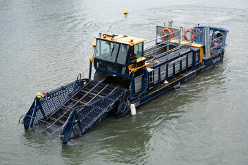 Fototapeta premium Paris, France - 07 27 2025: La Villette Basin. Detail view of a water cleaning boat sailing on the canal