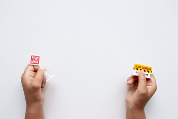 Hands holding mini caution signs on white background