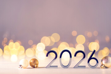 Metal numbers 2026 on a white table with Christmas decorations and bokeh lights. Happy New Year 2026 is coming concept.