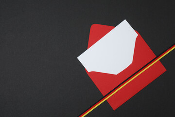 red envelope with ribbon on black background
