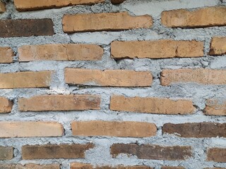 A rough, textured red brick wall with visible mortar joints, showcasing a classic and durable construction material.
