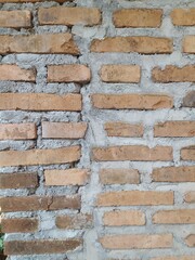 A rough, textured red brick wall with visible mortar joints, showcasing a classic and durable construction material.