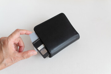 Hand choose credit card inside black wallet on white desk for financial, Buy now pay later,...