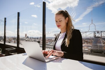 Businesswoman working on laptop on madrid rooftop terrace