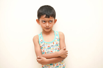 a cute indian asian boy of 5 years with gorgeous eyes and frowning unhappy facial expression