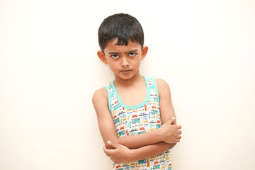 a cute indian asian boy of 5 years with gorgeous eyes and frowning unhappy facial expression