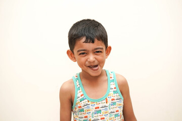a naughty cute indian asian boy of 5 years with gorgeous eyes and frowning alas, oh-no expression in light background