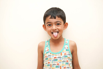 tongue out kid-a cute indian asian boy of 5 years with gorgeous eyes and facial expression