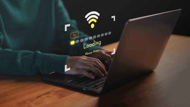 Person using a laptop computer with slow internet connection icon and loading screen interface. Concept of technology delay, network issues, data buffering and low Wi-Fi signal during online activity.