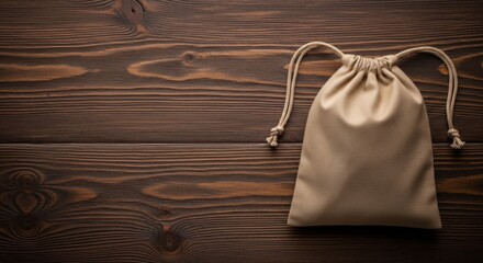 Simple drawstring pouch made of natural fabric rests on a rustic wooden surface