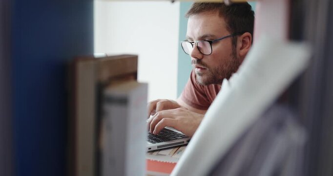 A man reacts with surprise and joy while working on his laptop, clearly impressed by helpful AI-generated results during a home office session.