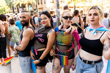 Group of friends showing rainbow flags at pride parade