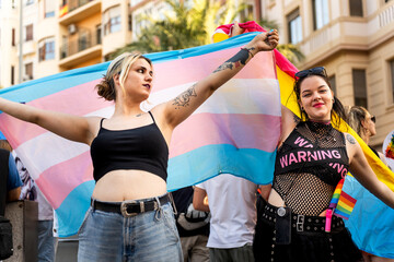 Two proud transgender activists holding transgender flag at pride parade