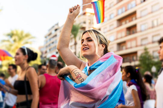 Transgender activist waving transgender pride flag at pride parade