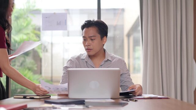 Asian business professionals face difficult conversation expressing extreme stress and frustration during a tense workplace meeting office problem