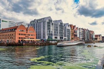 The Motława River waterfront with modern and historic architecture in Gdańsk, Poland.