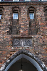 Detail of a historic Brick Gothic gate with a coat of arms in Gdańsk, Poland.