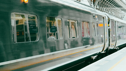 Green colored train engine on rails in city landscape, modern transport scene