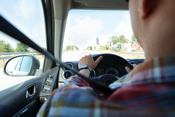 Man driving car with steering wheel, closeup