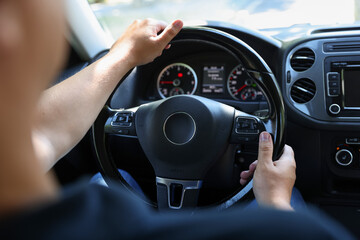 Man driving car with steering wheel, closeup
