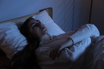 Frustrated woman suffering from insomnia in bed at home