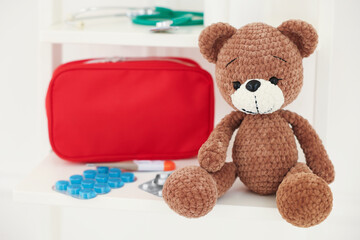 Pediatrics concept. Toy bear with pills on white background