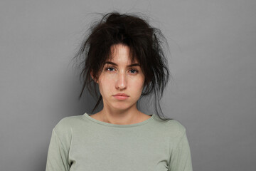 Woman suffering from hangover on grey background