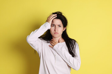 Woman suffering from hangover on yellow background