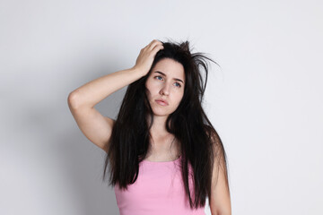 Woman suffering from hangover on light grey background