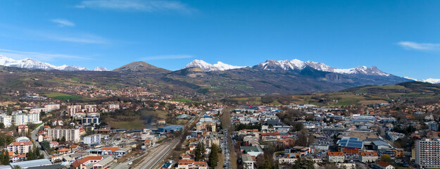 Wide drone panorama of Gap city in southeastern France with buildings, train tracks and majestic...