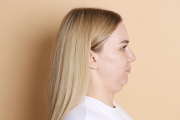 Woman with double chin on beige background
