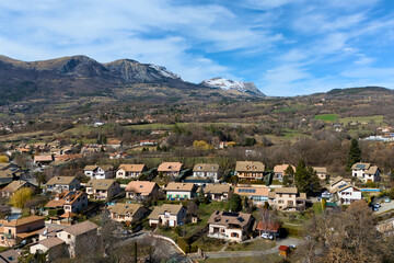 Drone view of a quiet suburban neighborhood with traditional houses and scenic mountains in the...