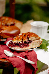 Close-up of a cherry pie slice with lattice crust and juicy filling on rustic plate, tea cup nearby. Perfect for bakery promotion or cozy lifestyle visuals.
