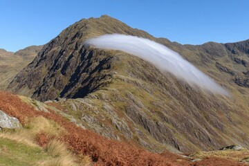 Mountain ridge draped in a flowing cloud