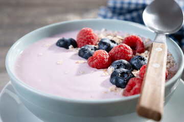 Healthy smoothie bowl with berries on wooden table