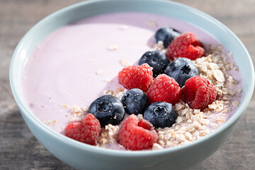 Healthy smoothie bowl with berries on wooden table. Close up