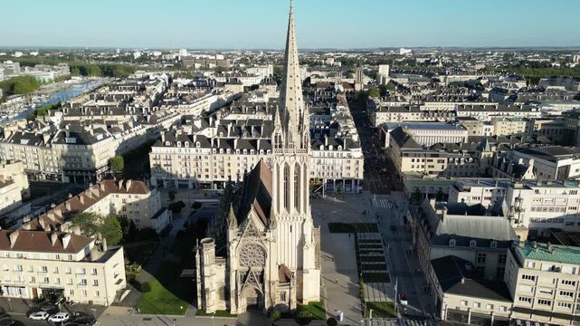 Aerial view of the spire of the Saint-Pierre church reaching to the sky surrounded by buildings and streets, Caen, Normandy, France.