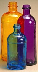 Three colorful glass bottles of different shades