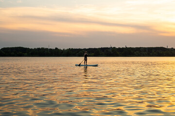 Silhouette of a beautiful woman on Stand Up Paddle Board. SUP.