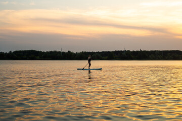 Silhouette of woman on Stand Up Paddle Board. SUP.