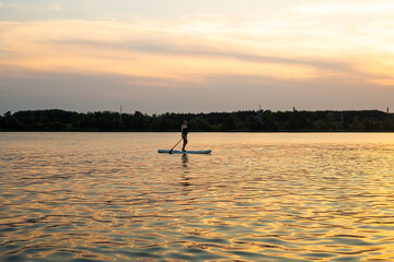 Silhouette of a beautiful woman on Stand Up Paddle Board. SUP.