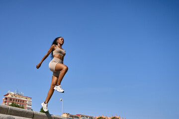 Young sporty woman jumping up the stairs in the city