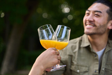 Friends toasting with orange juice in nature