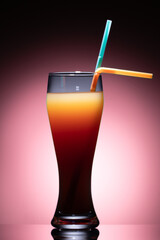 Glass of orange juice with a straw. Two straws are inserted into the drink: one 