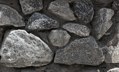 Rough granite blocks in a massive old masonry stone wall panoramic stock image  