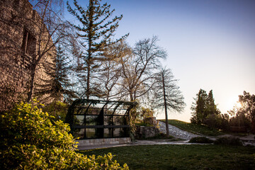 A charming stone building and a sleek glass structure nestled among lush greenery.
